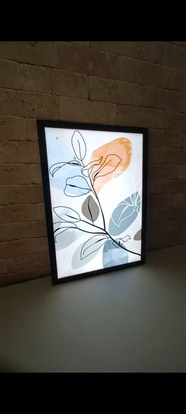 Quadro decorativo iluminado com arte botânica em ambiente residencial