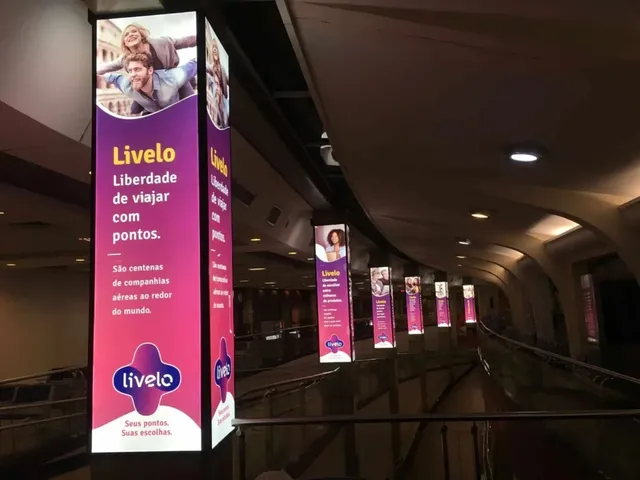Série de totens iluminados da campanha Livelo instalados em colunas de aeroporto
