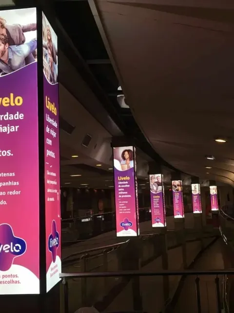 Série de totens iluminados da campanha Livelo instalados em colunas de aeroporto